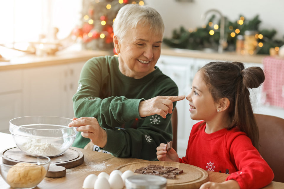 A grandmother baking with her granddaughter in the kitchen