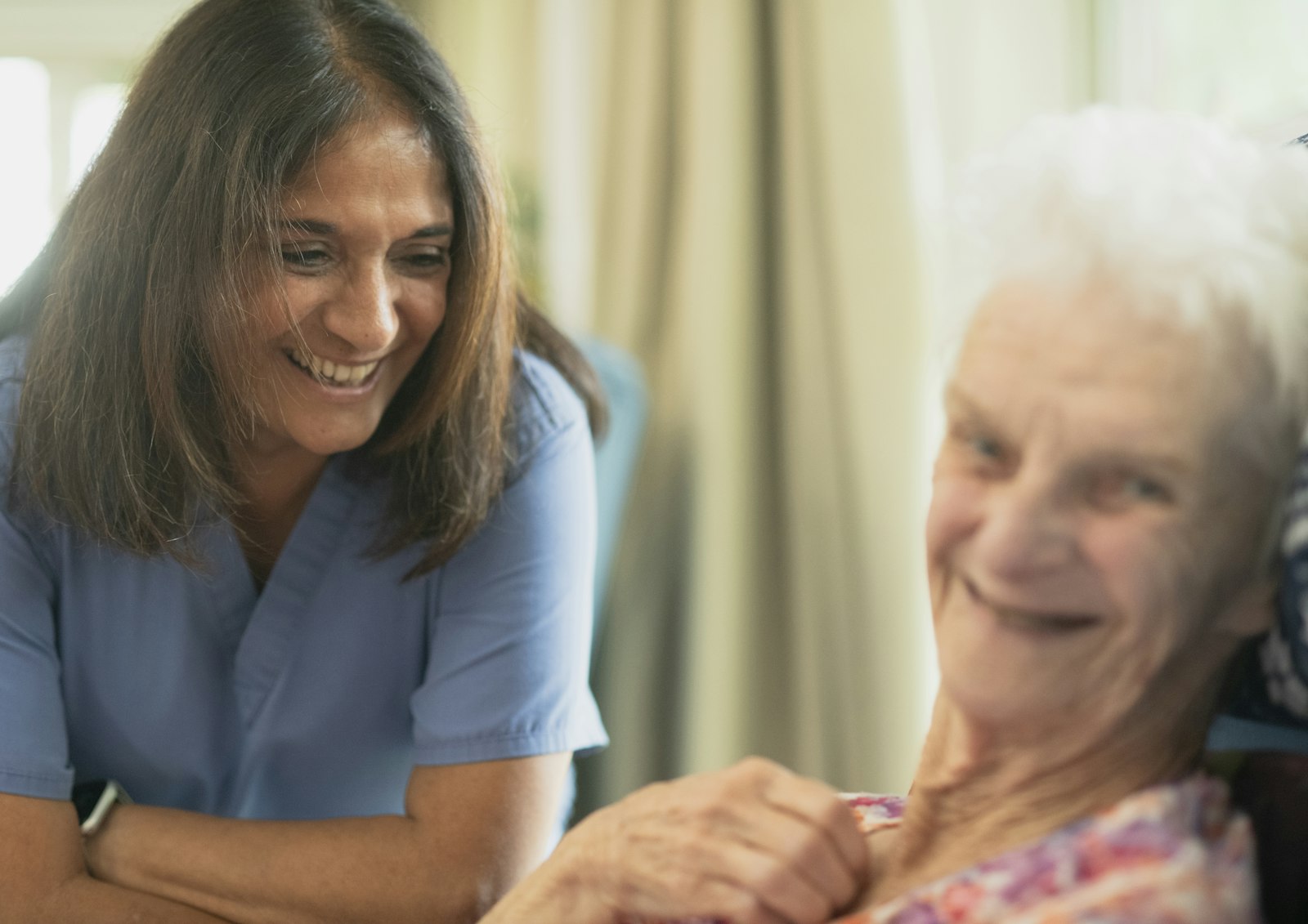 A smiling support worker visiting an older woman at home